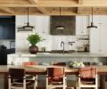The York College refectory table grounds the reclaimed white oak ceiling. The kitchen is framed by a custom concrete counter and island and Ann Sacks handmade Idris tile by Ait Manos.