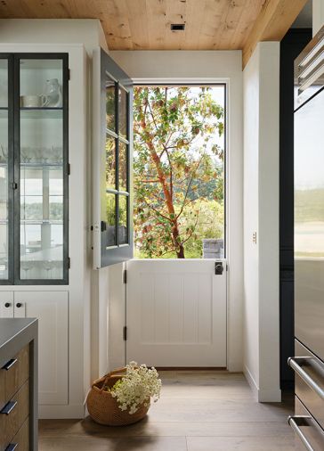 Adding to the charm of the home, a Dutch door by Northstar Woodworks brings the fresh air in. The glass cabinet doors reiterate the mullioned exterior windows.