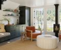 Guests are welcomed by Josh Green chairs and a Housewright Gallery ottoman alongside the kitchenette featuring built-in cabinets with bench seating.