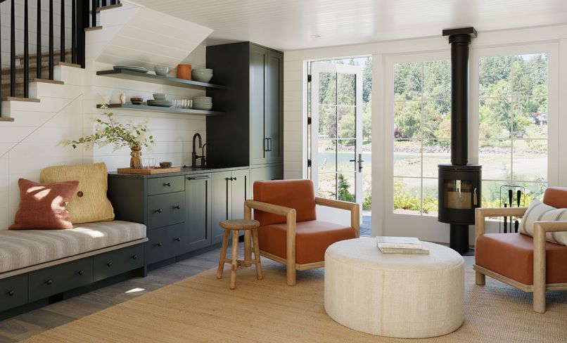 Guests are welcomed by Josh Green chairs and a Housewright Gallery ottoman alongside the kitchenette featuring built-in cabinets with bench seating.