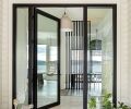 Guests are greeted by a Fleetwood door and windows from Cherry Creek Windows & Doors as they enter the beach home across a porcelain tile entryway.