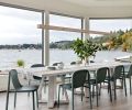 A pendant grey-washed oak linear LED light warms reclaimed whitewashed teak table and Blu Dot Decade chairs which are made from recycled milk cartons.