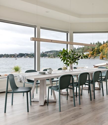 A pendant grey-washed oak linear LED light warms reclaimed whitewashed teak table and Blu Dot Decade chairs which are made from recycled milk cartons.