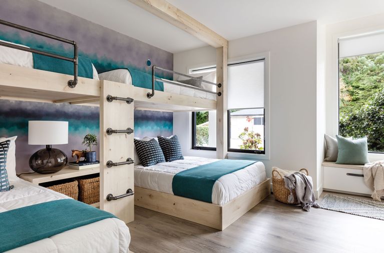 Children delight in the unique whitewashed rustic alder bunkbed configuration with sturdy custom mounting hardware. The Wolf Gordon watercolor wallcovering acts as a soft reminder of the Camano Island skyline. Window seat with leather pull drawer mimics the built-in dresser.