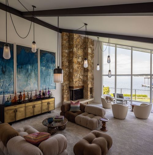 ABOVE In the living room, custom lighting from Apparatus Studio hangs above the Camaleonda sofa from B&B Italia, and an Oxley Coffee Table in chocolate marble from Soho Home. The refurbished fireplace gives off a soft glow.