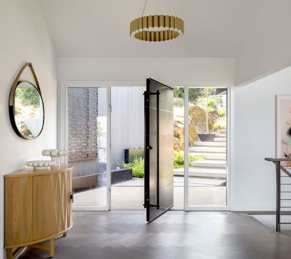 In the entry, find herringbone oak flooring from Element Hardwood Floors, a custom pivot door by Dyna Builders, and Benjamin Moore “Chantilly Lace” throughout.