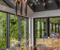 Lighting from Roll & Hill hangs above the rich walnut Cross Extension Table from Design Within Reach. A Burlwood Three-Drawer Chest from Burke Décor holds pretty family finds.