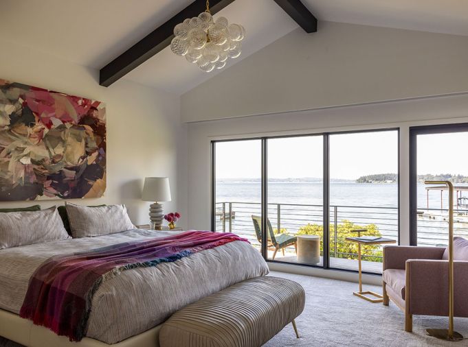 Views are aplenty from the primary bedroom, where the “Peony Press, 2022' painting by Emily Leonard from Winston Wachter Fine Art hangs above a Parallel King Bed from DWR. The pleated leather bench is from Arden Home.