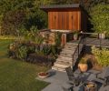 The patio area is furnished with a spa and sauna, and just below, an X Series Smokeless Fire Pit with porcelain bluestone pavers from Mutual Materials and seats from Room & Board.