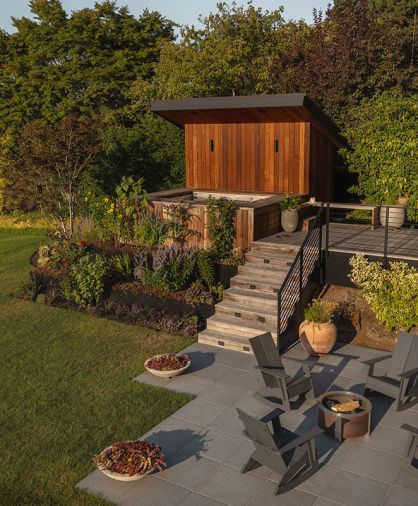 The patio area is furnished with a spa and sauna, and just below, an X Series Smokeless Fire Pit with porcelain bluestone pavers from Mutual Materials and seats from Room & Board.