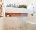 An expansive, curbless, walk-in shower now facilitates easy aging-in-place, select finishes like the Wayfair Merola Tile on the floor and Terracotta tile from CFM in the linear storage niche, both a nod to the client’s Spanish heritage. A towel warmer and shower fittings are the finishing touch.