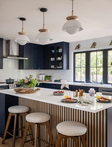 A custom slat treatment on the island is a sculptural statement which ties to the oak flooring. The island is illuminated by Modern Nordic Lighting ceiling pendants from Homdiy.