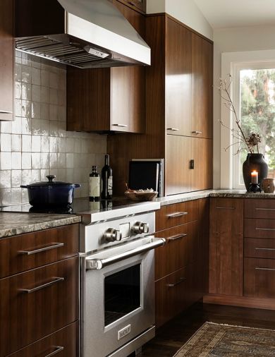 Cabinetry by Baywood Cabinets are stacked full-height to the ceiling to maximize storage, with a Clé Tile backsplash and granite counter from Architectural Surfaces. The Wolf range and oven, Sub-Zero refrigerator and freezer and Zephyr undercounter wine refrigerator were sourced through Albert Lee Appliance.