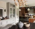In the dining room, an artistic lighting installation by Hubbardton Forge from Seattle Lighting elevates the dining experience, while a built-in buffet makes serving easy.