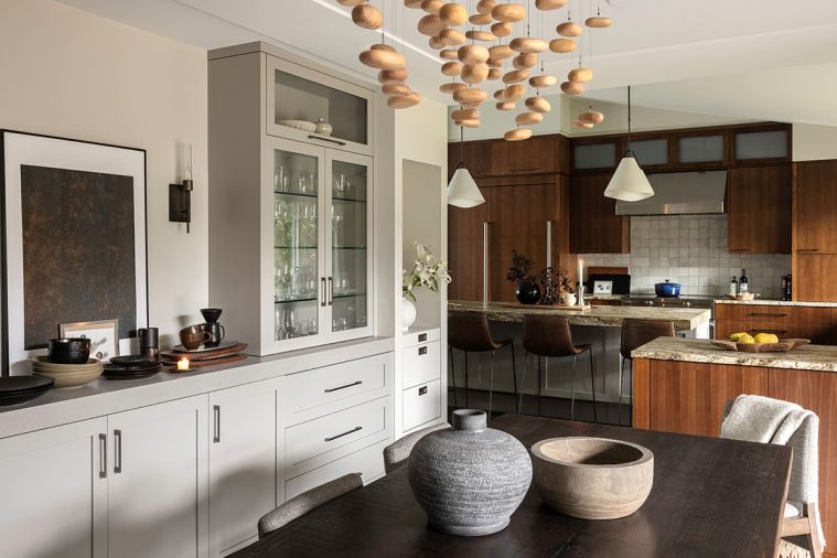 In the dining room, an artistic lighting installation by Hubbardton Forge from Seattle Lighting elevates the dining experience, while a built-in buffet makes serving easy.