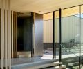 Blackened steel pivot door from Flux Design with white oak handle is carved midway to perfectly fit a hand. KN Visions cantilevered the hollow boxed entry stair treads without using fasteners. The detached garage opposite the main entry includes a studio, bath and storage.