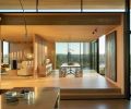 Looking from the kitchen, the dining room features a Slab Wishbone custom table and square BDDW chairs. A wood-slatted screen separates the sitting room.