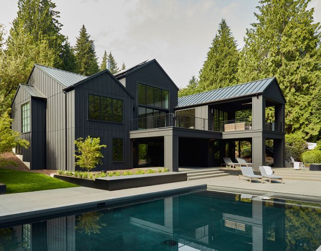 A geothermal pool is bordered with outdoor furnishings from Design Within Reach. The attractive and welcoming landscape architecture surrounding the home was provided by Scot Eckley Inc.
