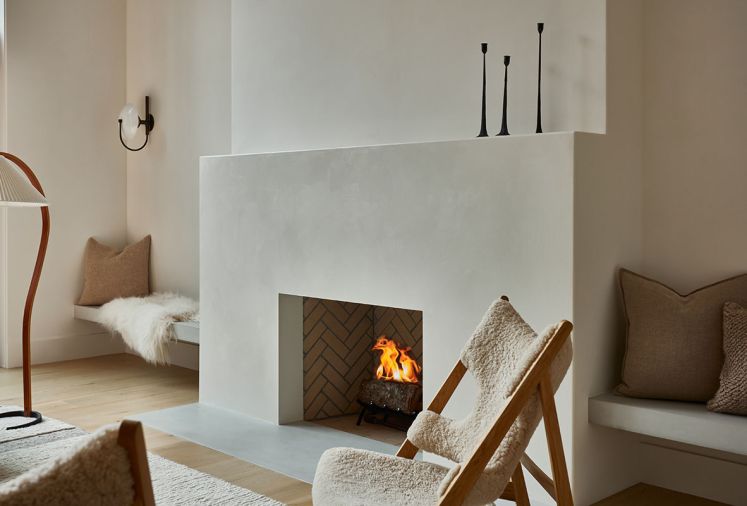The Portola limewash on the surrounding walls and clean lines of the fireplace create a calm environment in the living room. A Kofod-Larsen Knitting Chair sits nearby.