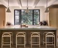 The kitchen island is topped with a concrete counter poured-in-place, while the bleached wide-plank oak flooring and neighboring dining table are from Montello Design.