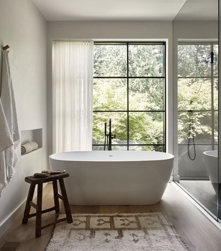 The primary bathroom beacons with a Kohler Purist tub filler accenting the Ocala tub and calming views. The airy window coverings are from Lesley Petty Workroom.