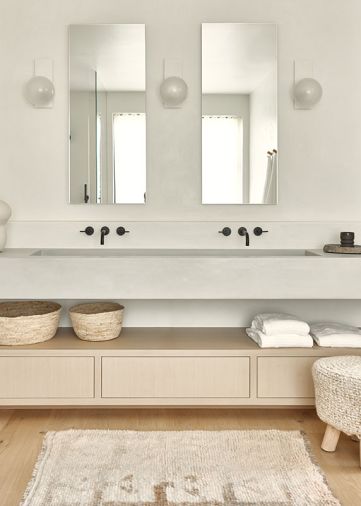 The modern and peaceful hues are carried through in the bathroom with a custom stain on the cabinetry from Northwest Custom Cabinets, topped with concrete counters crafted by Studio Make.