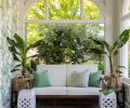 The wallpaper is the Sanderson Calathea Botanical Green from Kelly Forslund. Vintage ceramic side tables and plants nestled in handwoven baskets frame the love seat.