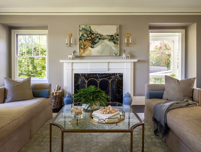 In the living room, a coffee table designed by Nifelle Design and built by Culver Glass and Emmerling Ironworks sits with Andante Plain Recamiers from Kravet.