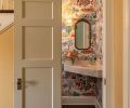 The petite powder room under the stairs reveals Le Jardin Du Palais “Lever du” wallcovering from Pierre Frey and a 1940 s antique mirror.