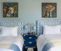 The headboards are upholstered in Firecrackers “Sky” from Schumacher. They are paired with Benjamin Moore “Wickham Gray” on the walls, a Tansu 2-Drawer from Bungalow 5, and a Thomas O’Brien lamp with matching custom lampshades.