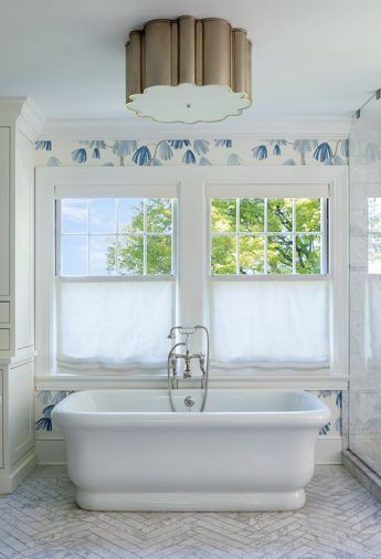 The Alexa Hampton Markos light in polished nickel was installed above the soaking tub and Carrera White Marble floor.