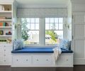 The existing cabinetry and window seat were perked up with thoughtful touches. A custom roman shade in Schumacher Skittles “Blueberry/Sky”, custom pillows from Thibaut, and navy textured fabric upholstery from Kravet were added to create a comfy reading nook.