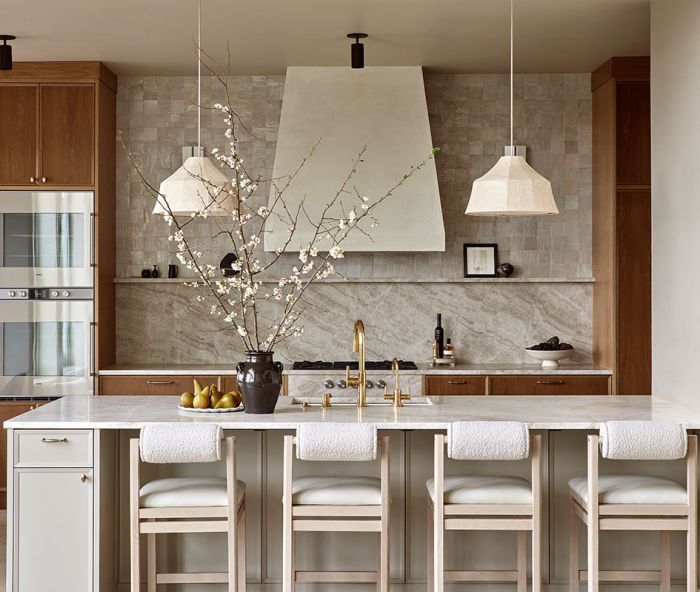 Anchored in natural materiality, the kitchen is awash in warm colors and organic textures. Custom cabinetry is plain-sawn white oak by Rockwood Cabinetry. Maiden Home counter stools and Newport Brass plumbing fixtures add sophistication, texture and shine.