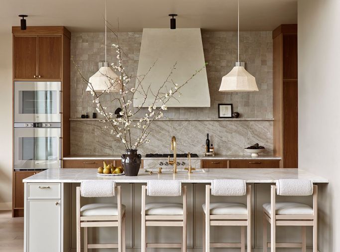 Anchored in natural materiality, the kitchen is awash in warm colors and organic textures. Custom cabinetry is plain-sawn white oak by Rockwood Cabinetry. Maiden Home counter stools and Newport Brass plumbing fixtures add sophistication, texture and shine.