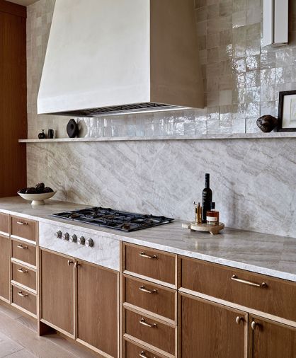 Quartzite in ‘Taj Mahal’ sets the tone for the kitchen. The undulating stone aprons the integrated cooktop and beautifully frames the Gagganau range from Standard TV & Appliance.