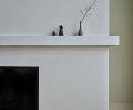 The original fireplace dominated the great room. A new custom plaster surround to match “Earthhaus Alabaster” brings it down to a more human level and a more holistic space.