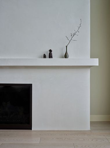 The original fireplace dominated the great room. A new custom plaster surround to match “Earthhaus Alabaster” brings it down to a more human level and a more holistic space.