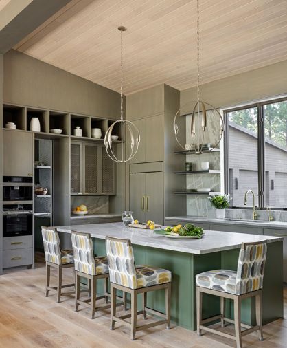 The kitchen has custom rift-cut white oak cabinetry with veneered finish by Northwest Custom Interiors, and dramatic chandeliers from Hubbardton Forge.