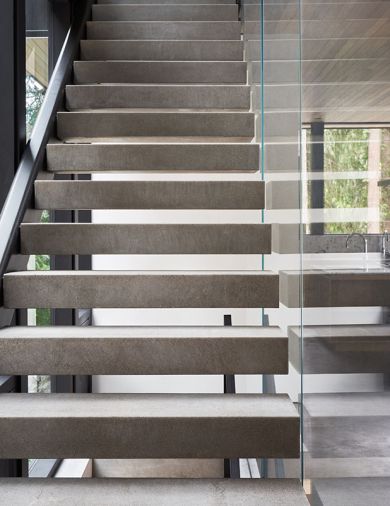 The stairwell, held by metal supports, is surprisingly poised without obstructing views, despite 200-pound concrete treads.