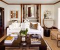 A Restoration Hardware sofa and coffee table sit with One Kings Lane chairs in leather upholstery and bronze framing.