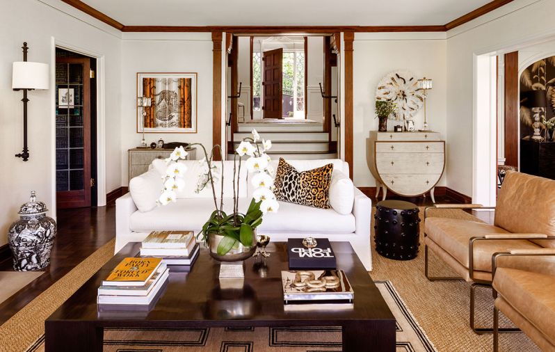 A Restoration Hardware sofa and coffee table sit with One Kings Lane chairs in leather upholstery and bronze framing.