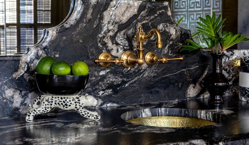 The bar counters are made of Titanium Gold leathered granite slabs, setting off a hammered brass sink and fixtures.