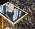 A vintage iron gold leaf table with black glass is a showstopper in the den.