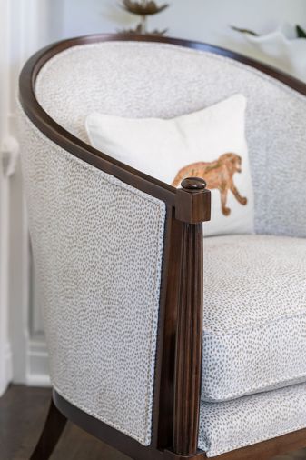 In the library, an arched wood-framed side chair from Baker Furniture is a cozy spot to read.