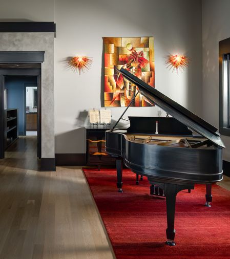 The doorway is custom Venetian plaster by Level 5, and the Caracole buffet lines the wall in a piano finish. Artwork includes custom lighting by artist Ed Pennebaker from Red Fern Glass.