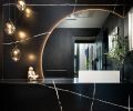 In the powder room, the floating vanity and full-height backsplash in Silestone Et Noir from Cosentino, while the Sonneman Liquid LED Pendants in smoked glass are from Northcoast Lighting.