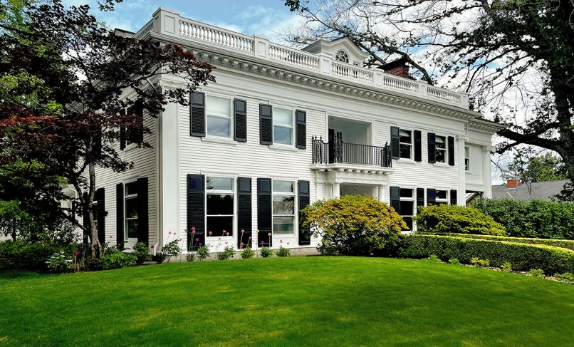 Arciform’s stunningly restored 1913 Colonial Revival painted Benjamin Moore “Pure White” sparkles in sunlight. The replicated wrought iron railing at center was raised 1.5 feet for safety reasons. Renovated double hung windows are paired with eye-catching black shutters.