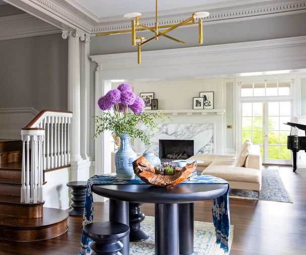 The Reaves stripped the staircase and millwork before its restoration. Benjamin Moore “Bruton White” molding is set against “Bone Black” walls. A makeover of a 1980s fireplace redesign features a Calacatta Cervaiole marble surround fabricated by Alpha Stoneworks.