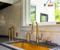 The adjacent kitchen’s Texas Lightsmith brass sink is set in Calacatta Extra and Saratoga Soapstone counters.