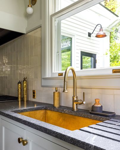 The adjacent kitchen’s Texas Lightsmith brass sink is set in Calacatta Extra and Saratoga Soapstone counters.